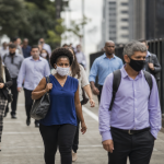 Trabalhadores brasileiros em deslocamento durante a rotina profissional em uma área urbana