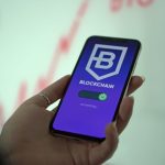 Mão segurando um smartphone com uma carteira digital de criptomoedas exibida na tela
