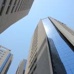Edifícios modernos no horizonte de Assunção sob céu azul, representando o contexto urbano e econômico do Paraguai