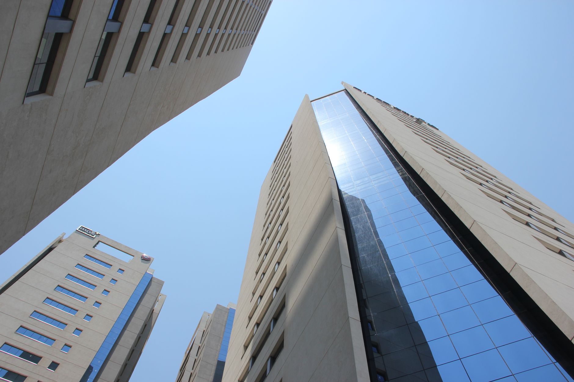 Edifícios modernos no horizonte de Assunção sob céu azul, representando o contexto urbano e econômico do Paraguai